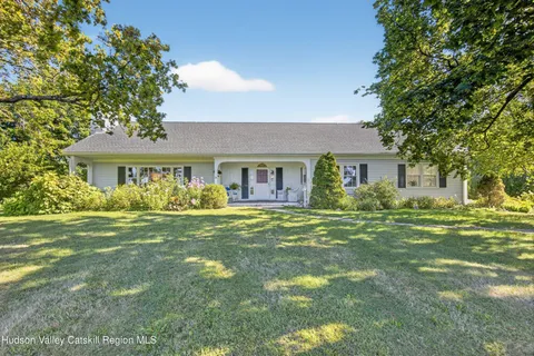 a large white kitchen with granite countertop lots of white stainless steel appliances and white cabinets