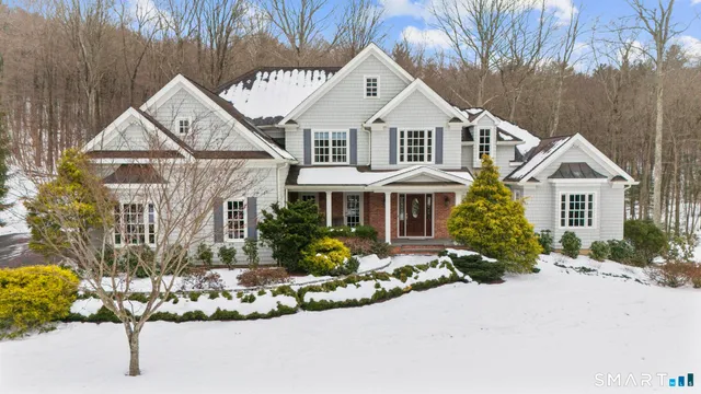 a front view of a house with a yard and potted plants