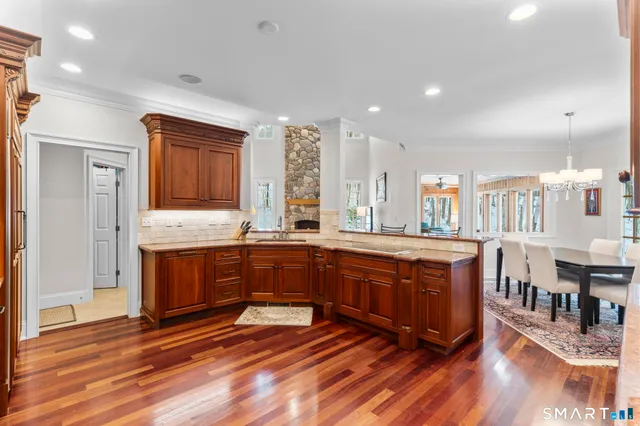 a view of kitchen with stainless steel appliances wooden floor and cabinets