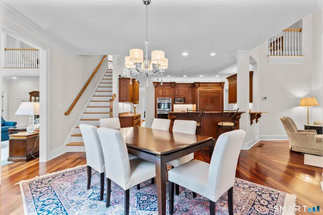 a dining room with furniture a chandelier and wooden floor