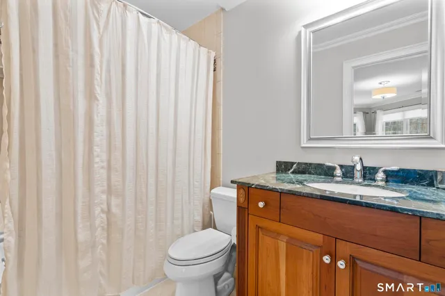 a living room with furniture a bookshelf and a window