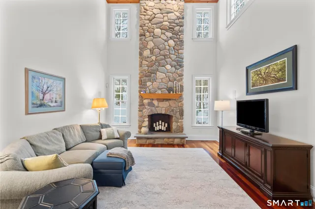 a kitchen with stainless steel appliances kitchen island granite countertop a table chairs in it and wooden floors