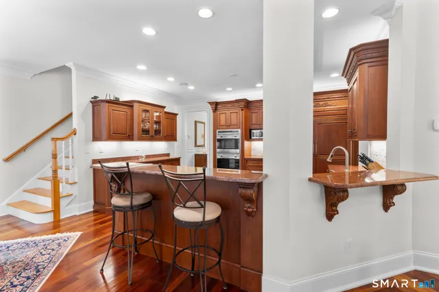 a kitchen with stainless steel appliances granite countertop a refrigerator a stove top oven and a sink with dishwasher