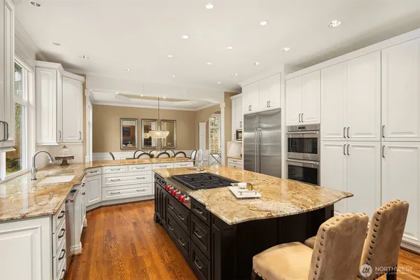 a kitchen with granite countertop kitchen island stainless steel appliances a sink and a counter top space