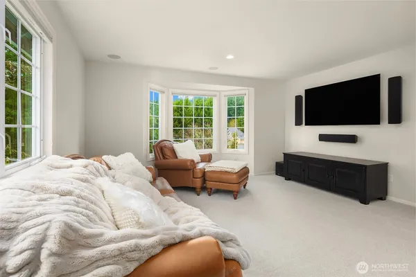 a bedroom with bed television and window