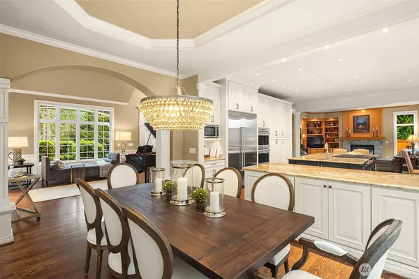 a view of a dining room and livingroom with furniture wooden floor a chandelier