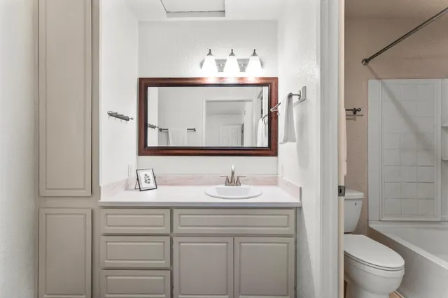 a bathroom with a sink vanity toilet and shower