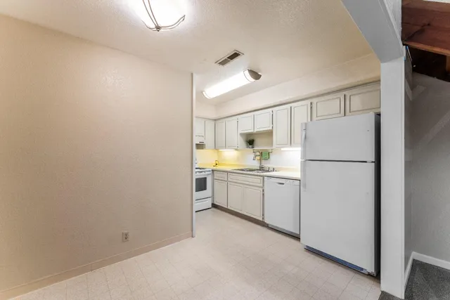 a kitchen with refrigerator and cabinets
