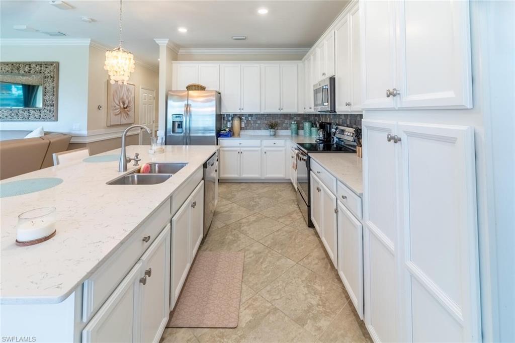 9596 Trevi Court, Unit 5446 Naples, FL 34113 - Photo 11 of 50 a kitchen with kitchen island granite countertop lots of counter top space and sink