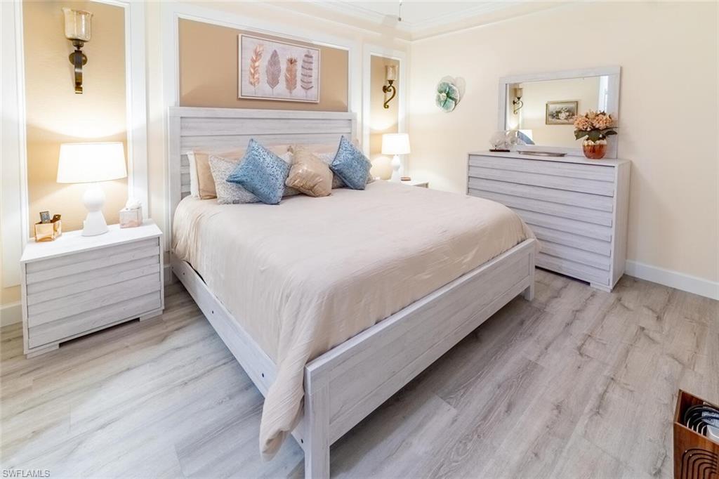 9596 Trevi Court, Unit 5446 Naples, FL 34113 - Photo 13 of 50 a large bed sitting in a bedroom next to a window