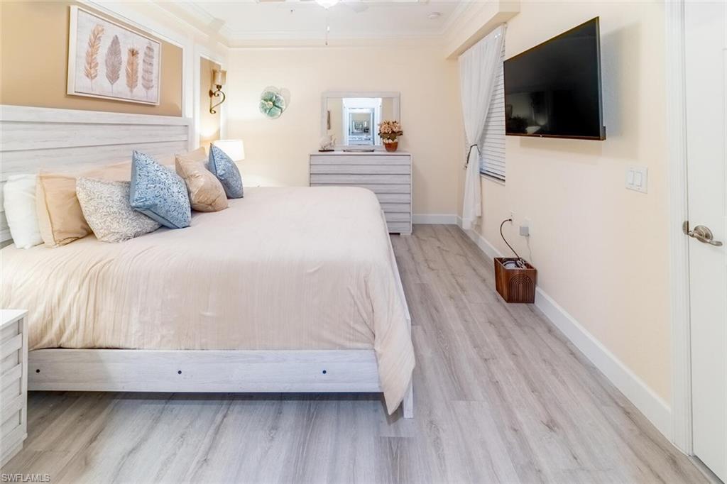 9596 Trevi Court, Unit 5446 Naples, FL 34113 - Photo 14 of 50 a bedroom with a bed and a flat screen tv