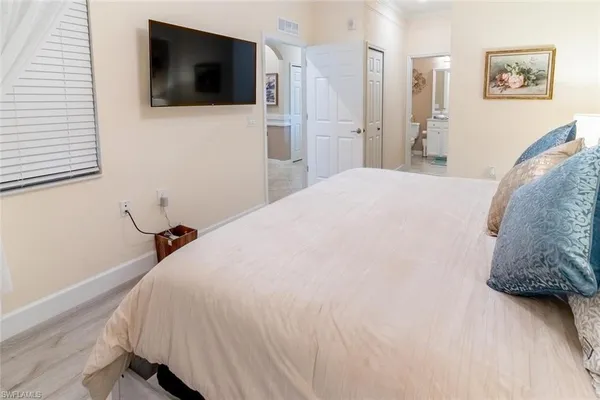 a bedroom with a bed and a flat screen tv