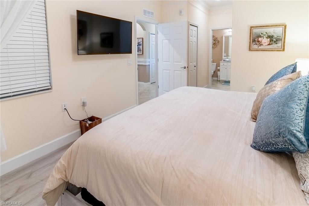 9596 Trevi Court, Unit 5446 Naples, FL 34113 - Photo 15 of 50 a bedroom with a bed and a flat screen tv