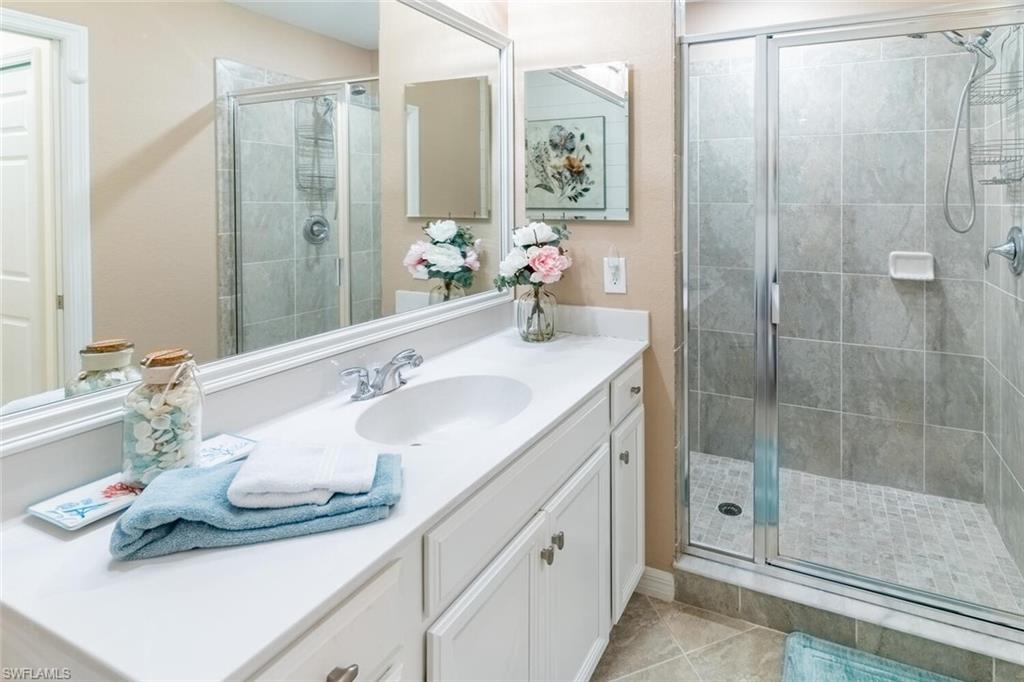 9596 Trevi Court, Unit 5446 Naples, FL 34113 - Photo 17 of 50 a bathroom with a sink and a mirror