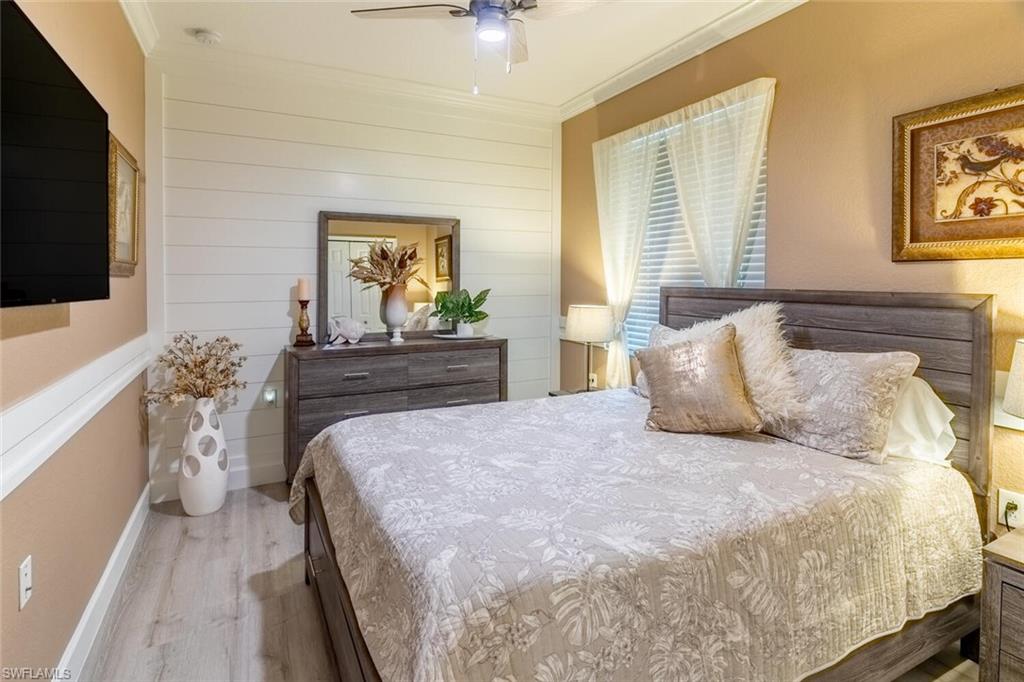 9596 Trevi Court, Unit 5446 Naples, FL 34113 - Photo 18 of 50 a bedroom with a bed and a flat screen tv