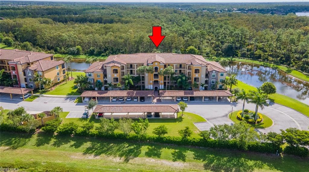 9596 Trevi Court, Unit 5446 Naples, FL 34113 - Photo 2 of 50 a view of a swimming pool with a garden and plants