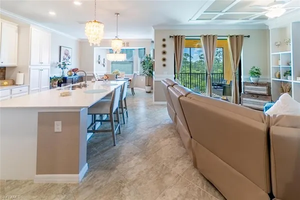 a living room with furniture a large window and chandelier