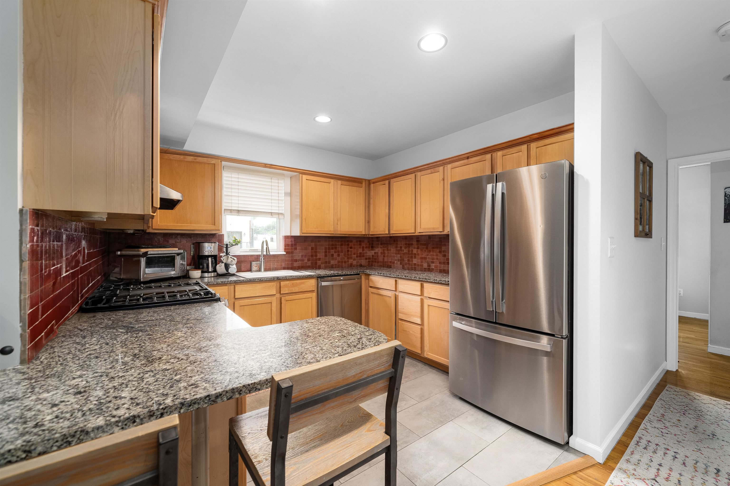 536 Grand Street, Unit 403 Hoboken, NJ 07030 - Photo 4 of 15 a kitchen with stainless steel appliances granite countertop a refrigerator a stove and a sink