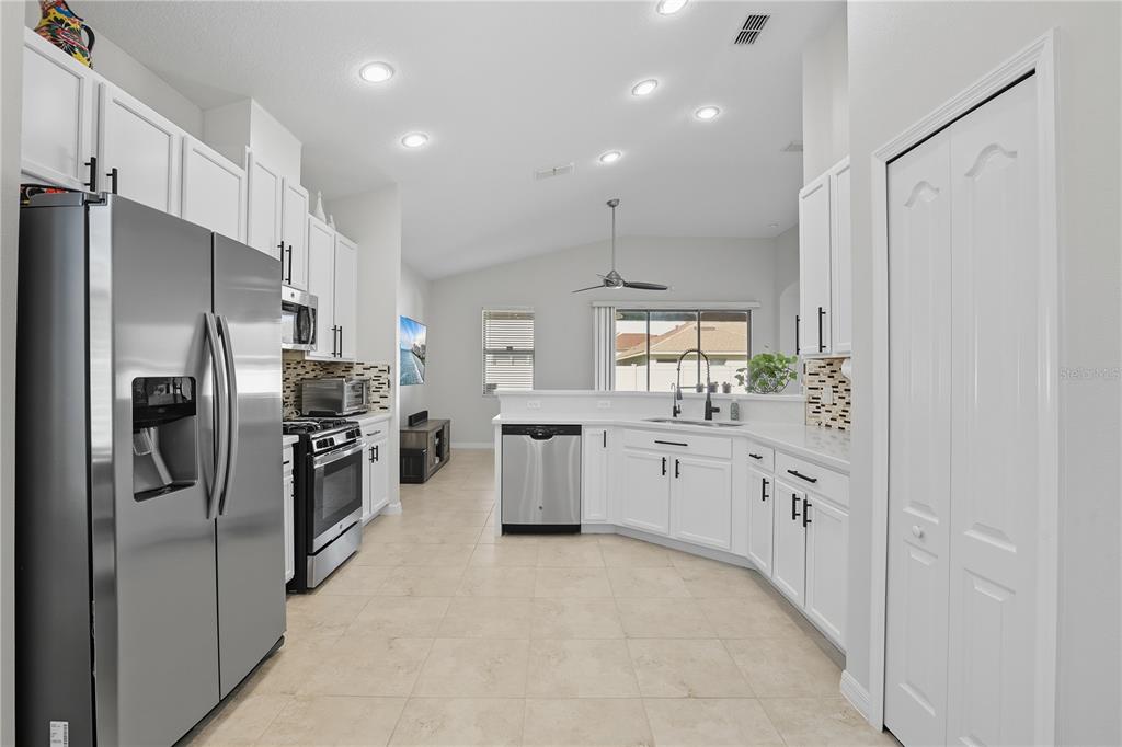 12154 Beach Fern Road Orlando, FL 32824 - Photo 11 of 34 a kitchen with stainless steel appliances a refrigerator sink and stove