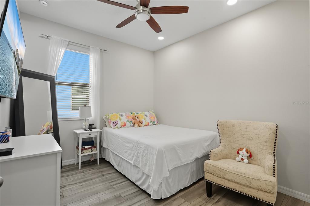 12154 Beach Fern Road Orlando, FL 32824 - Photo 16 of 34 a bedroom with a bed and a chandelier