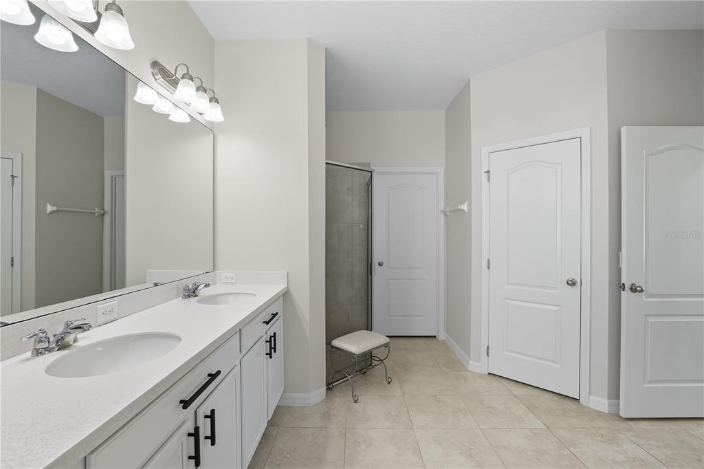 12154 Beach Fern Road Orlando, FL 32824 - Photo 19 of 34 a spacious bathroom with a double vanity sink mirror and toilet