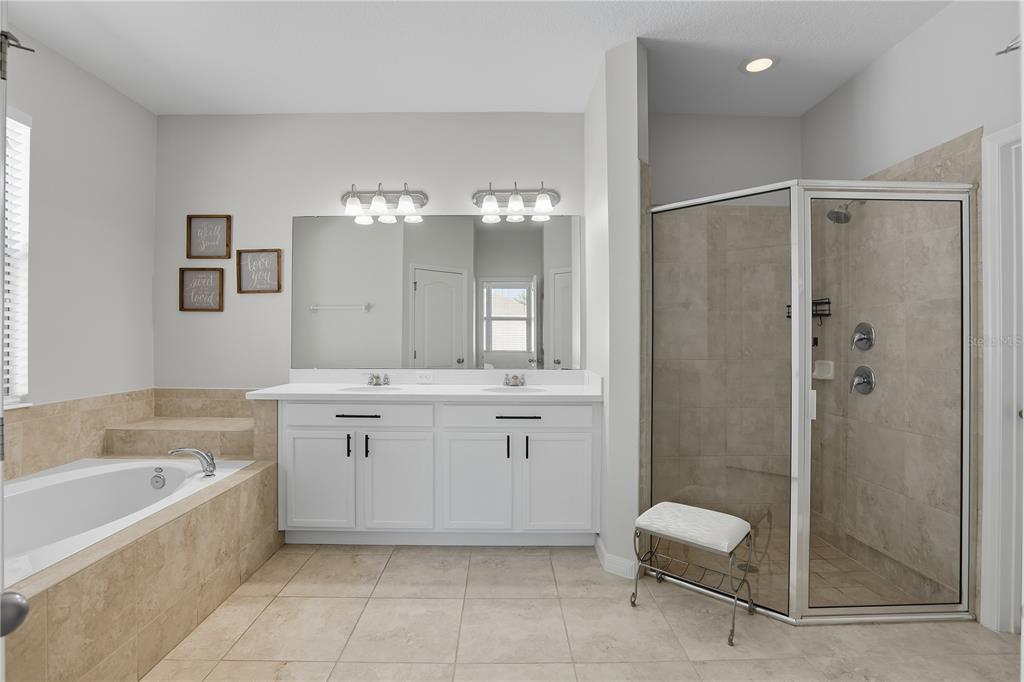 12154 Beach Fern Road Orlando, FL 32824 - Photo 21 of 34 a spacious bathroom with a shower a sink and a mirror