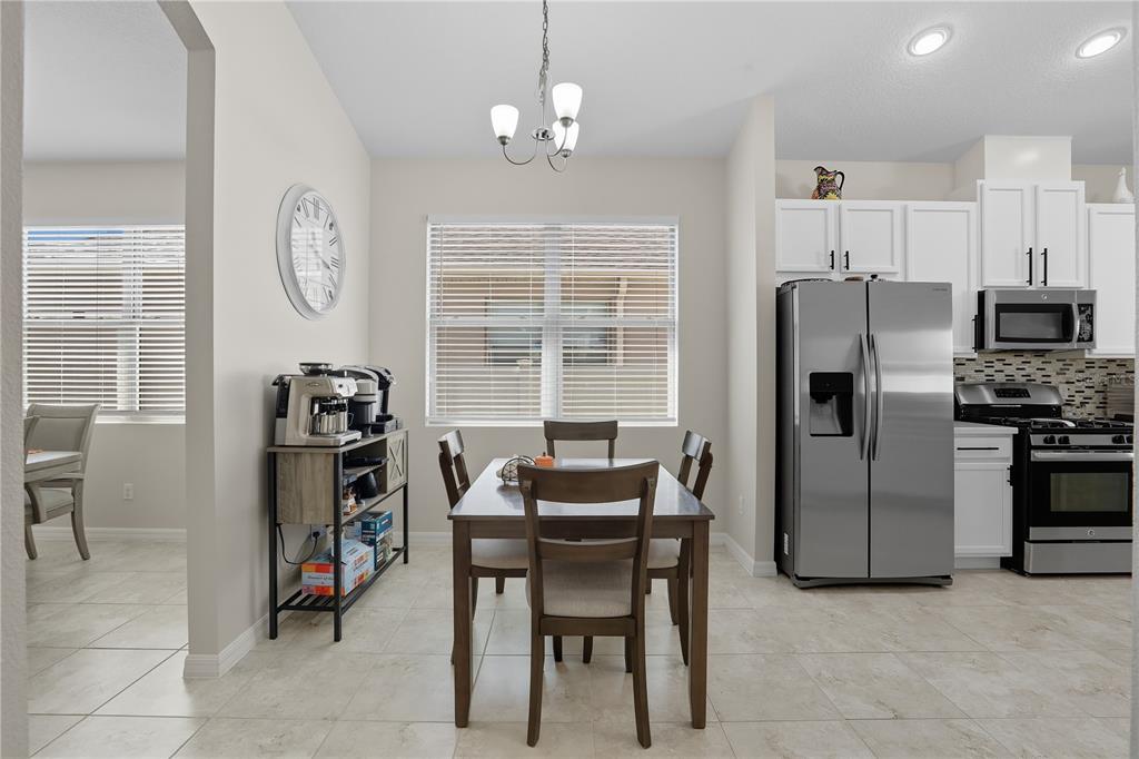 12154 Beach Fern Road Orlando, FL 32824 - Photo 6 of 34 a dining room with furniture and a chandelier