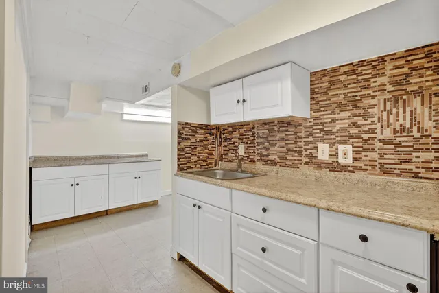 a view of a kitchen with white cabinets
