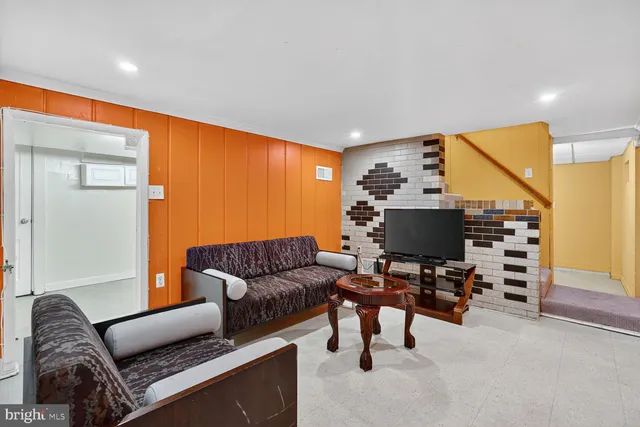 a living room with furniture and a flat screen tv with wooden floor