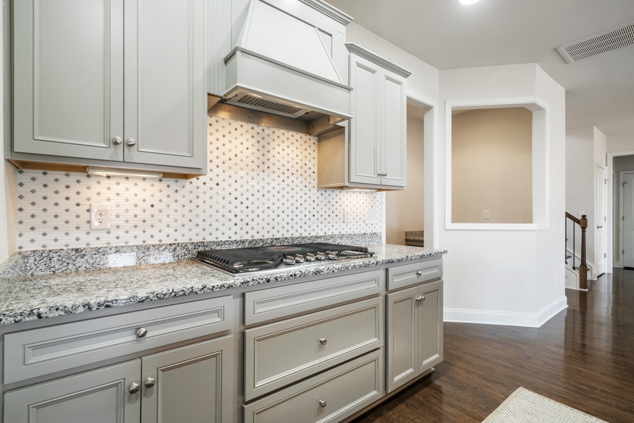 2995 Liverpool Drive Spring Hill, TN 37174 - Photo 9 of 37 a kitchen with granite countertop white cabinets and white appliances