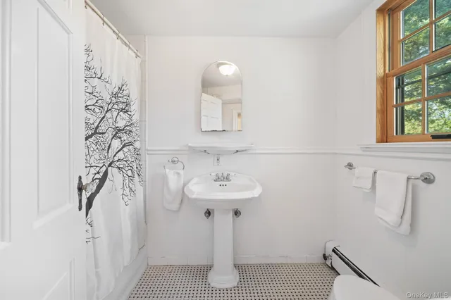 a bathroom with a sink a window and a mirror