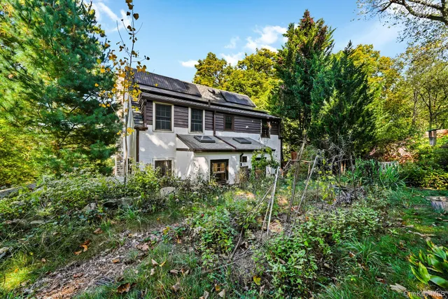 a front view of house with yard and trees around