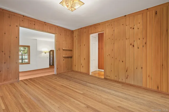 a view of an empty room with wooden floor and closet