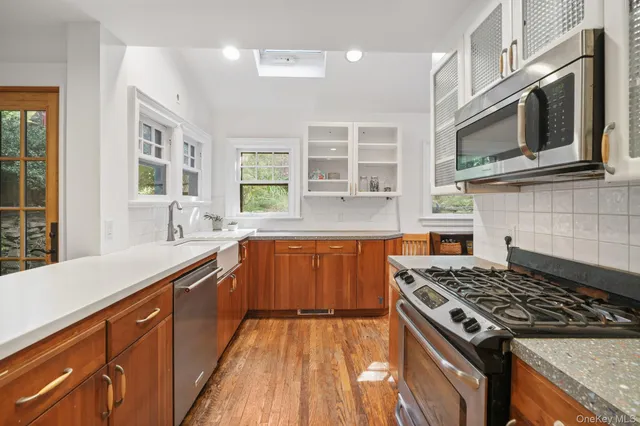 a kitchen with stainless steel appliances wooden cabinets and a stove top oven