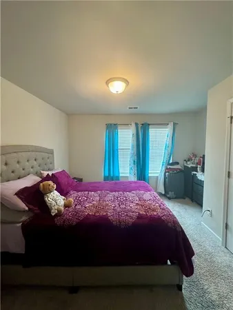 a bedroom with a bed dresser and a window