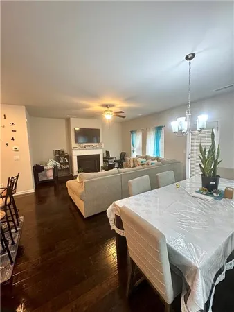 a view of a dining room and livingroom with furniture wooden floor a rug and a chandelier