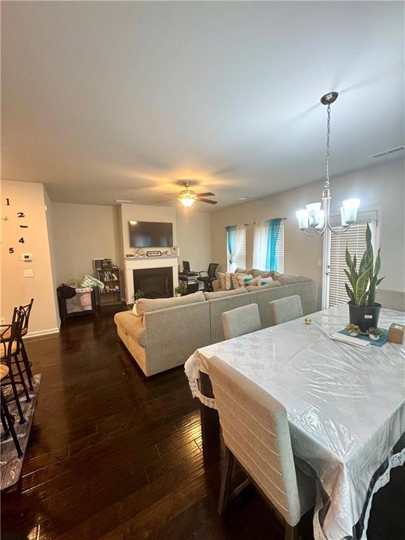 2188 Justify Lane, Unit 40 Lithonia, GA 30058 - Photo 8 of 21 a view of a dining room and livingroom with furniture wooden floor a rug and a chandelier