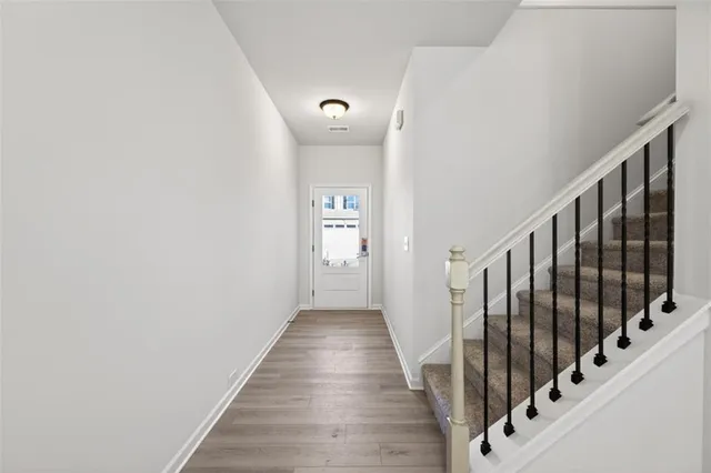 a view of a hallway with wooden floor and staircase