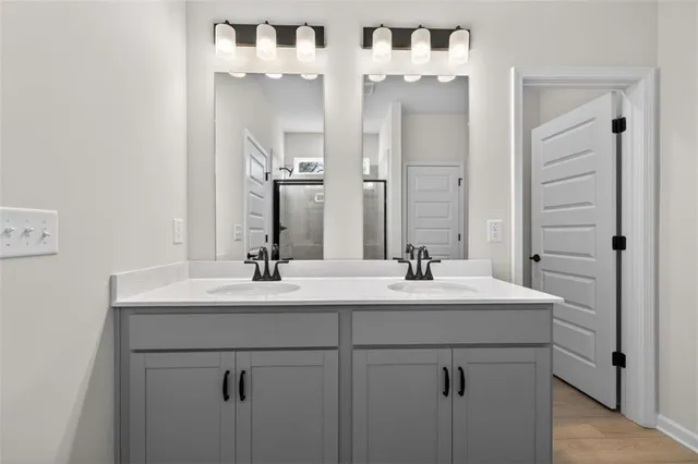a bathroom with double sink and two mirror