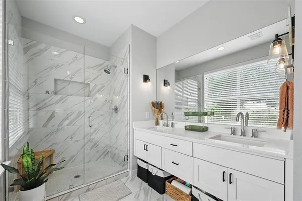 a bathroom with double vanity sink and a shower