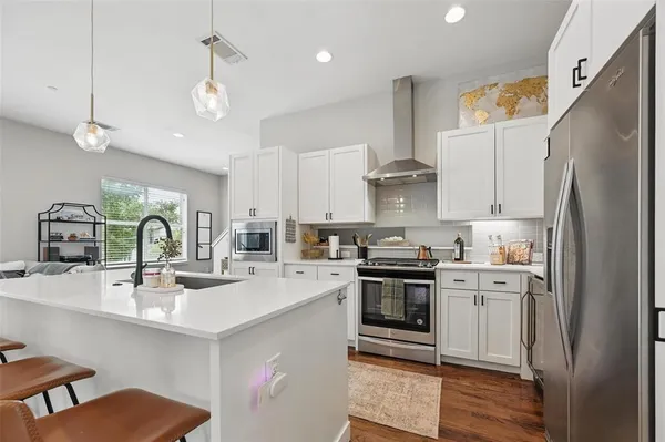a kitchen with stainless steel appliances granite countertop a sink stove and refrigerator