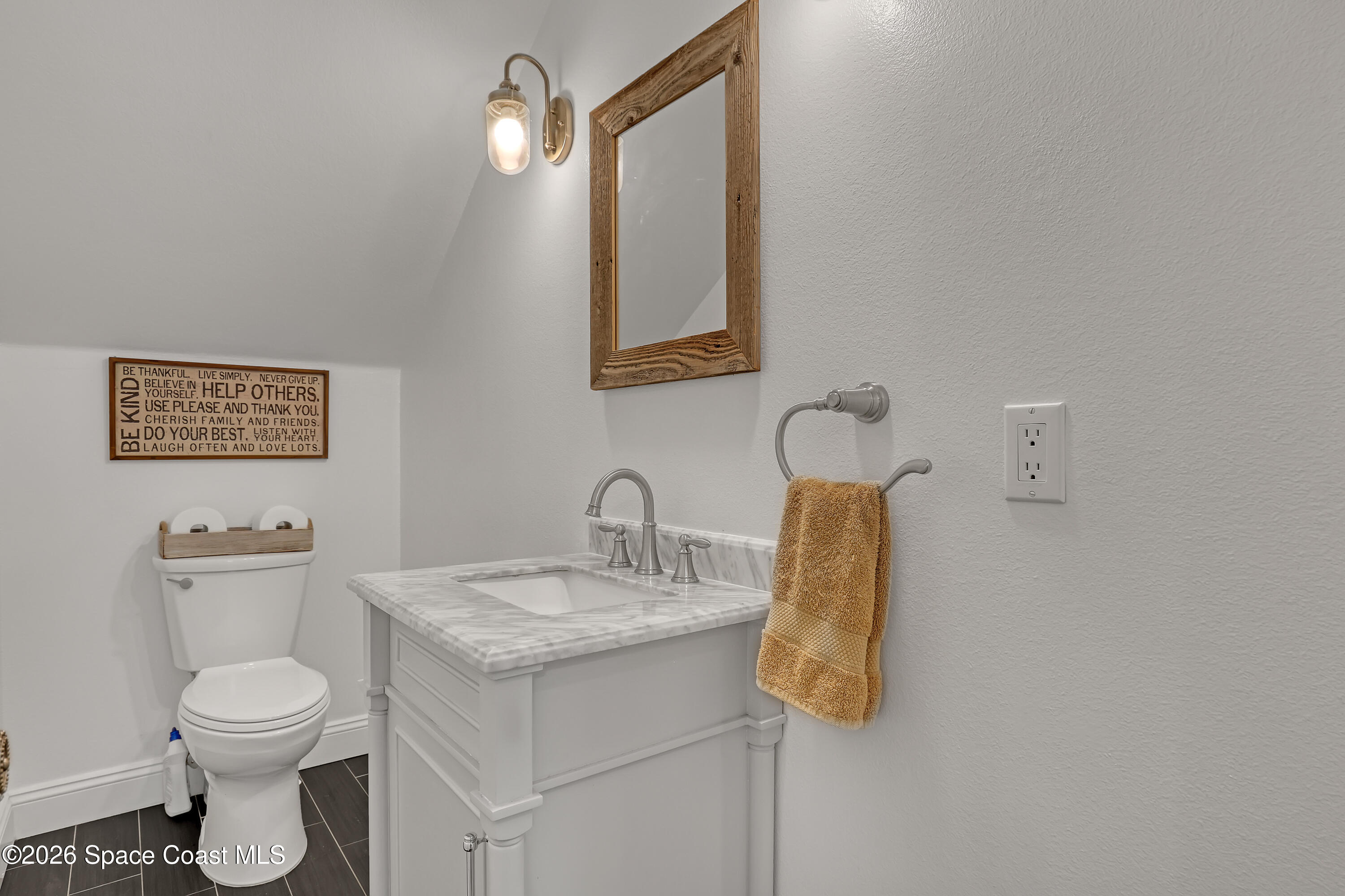 4200 Mustang Road Melbourne, FL 32934 - Photo 32 of 58 a bathroom with a toilet sink and mirror