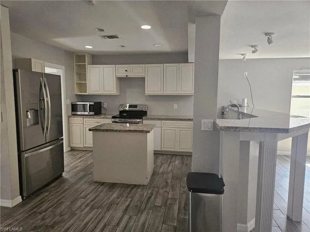 a kitchen with a refrigerator sink and cabinets
