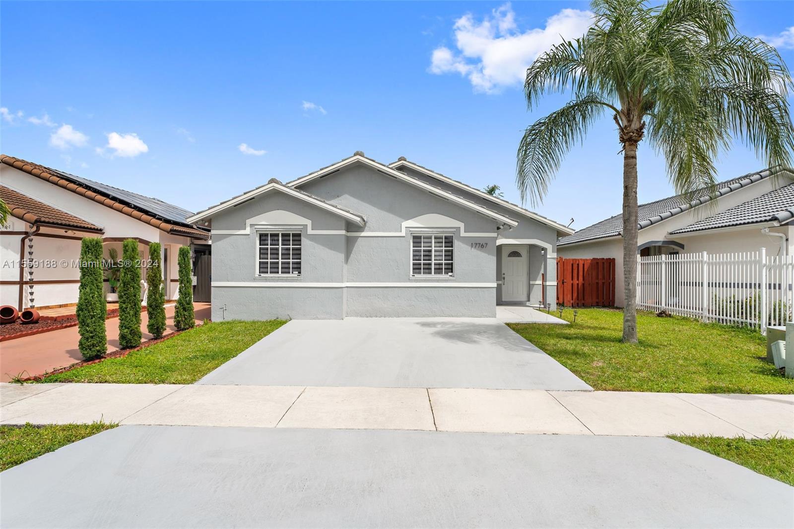 17767 Southwest 144th Avenue Miami, FL 33177 - Photo 1 of 21 a front view of a house with a garden and trees
