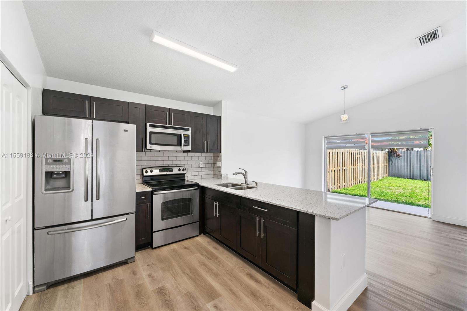 17767 Southwest 144th Avenue Miami, FL 33177 - Photo 6 of 21 a kitchen with stainless steel appliances a sink and a refrigerator