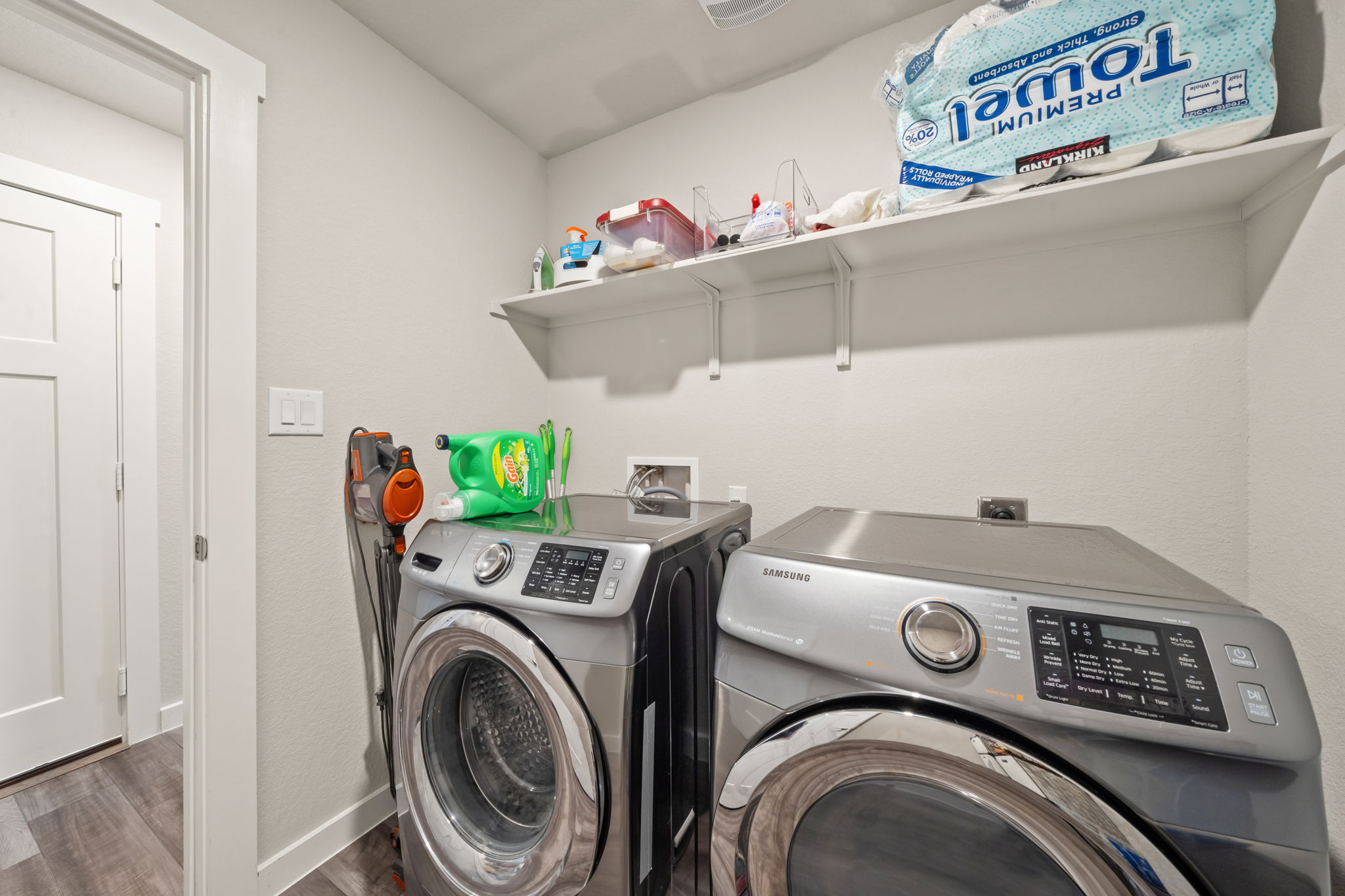 1117 Tipton Street Georgetown, TX 78633 - Photo 16 of 40 Dedicated laundry area featuring a white wall shelf, light gray walls, and wood-finish flooring