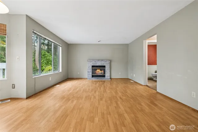 a view of an empty room with a window and a fireplace