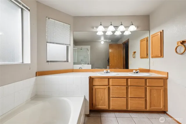 a bathroom with a tub sink and mirror