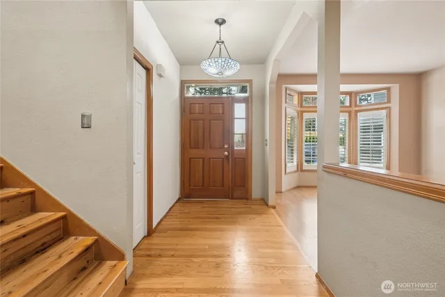 a view of a hallway with windows and chandelier