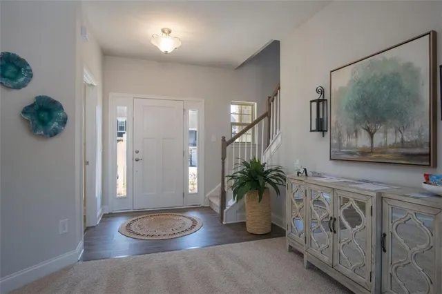 a view of a hallway with wooden floor and a potted plant